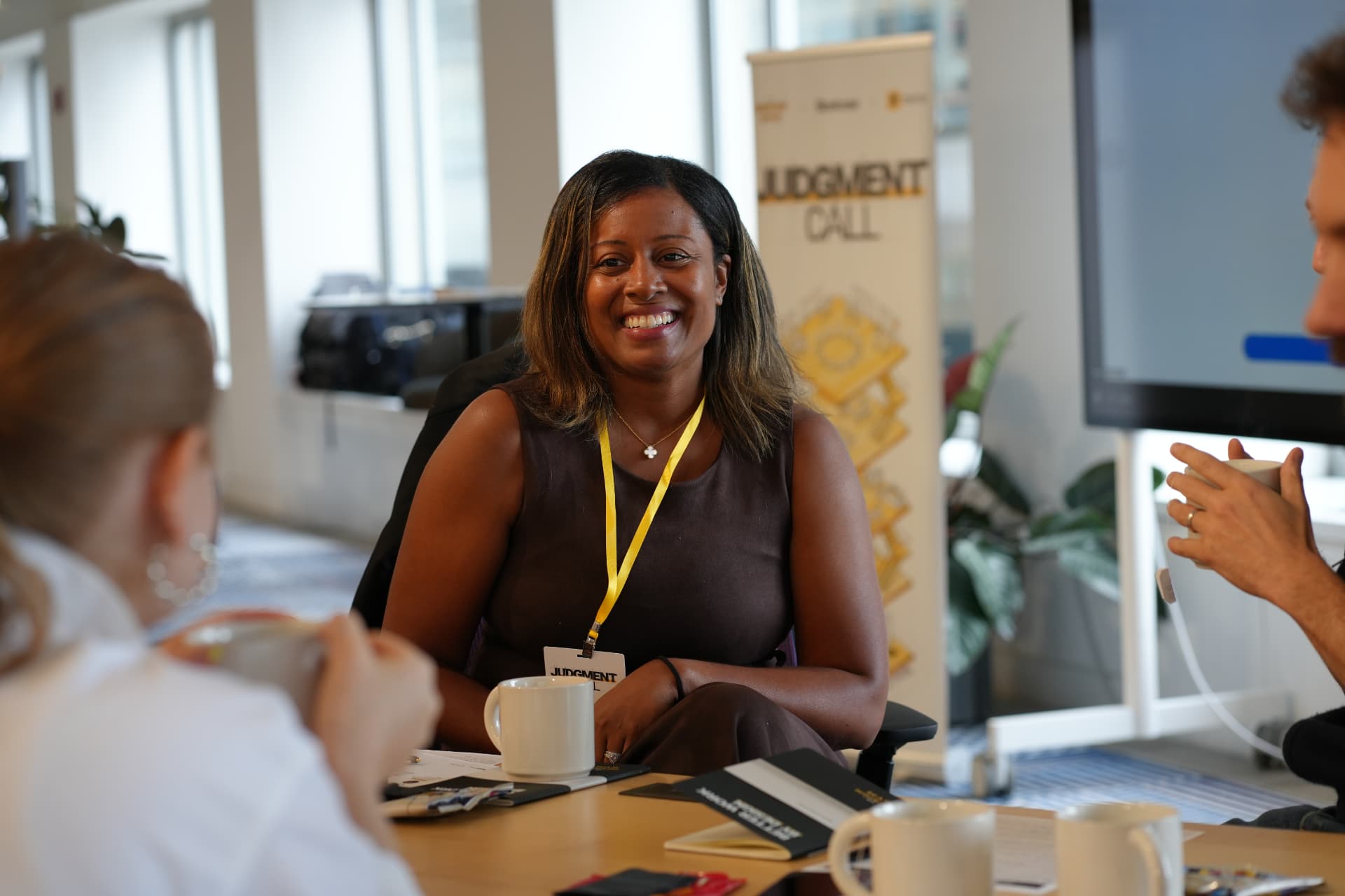 A smiling leader seated at the table during a small-group session